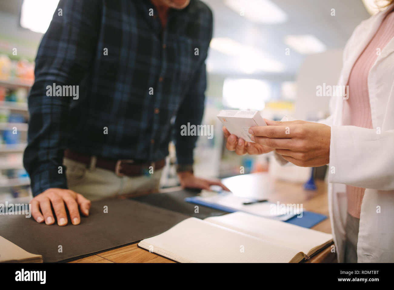 Femmina azienda farmacia medicina dare consigli al Cliente in farmacia shop. Il farmacista che spiega una medicina di prescrizione per il cliente. Foto Stock