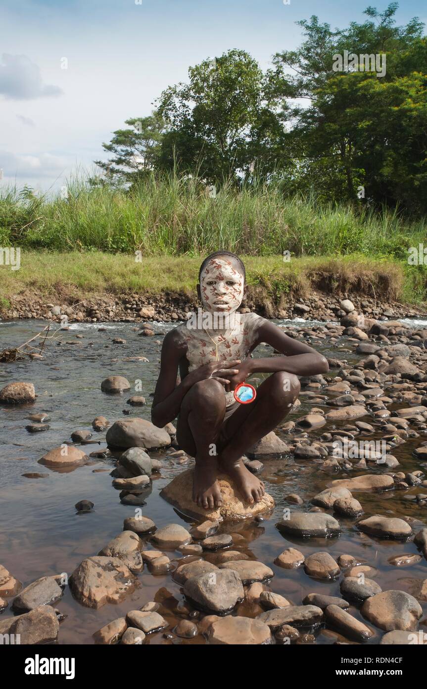 Surma ragazzo con trattamenti per il viso e per il corpo della pittura, Kibish, Omo River Valley, Etiopia, Africa Foto Stock