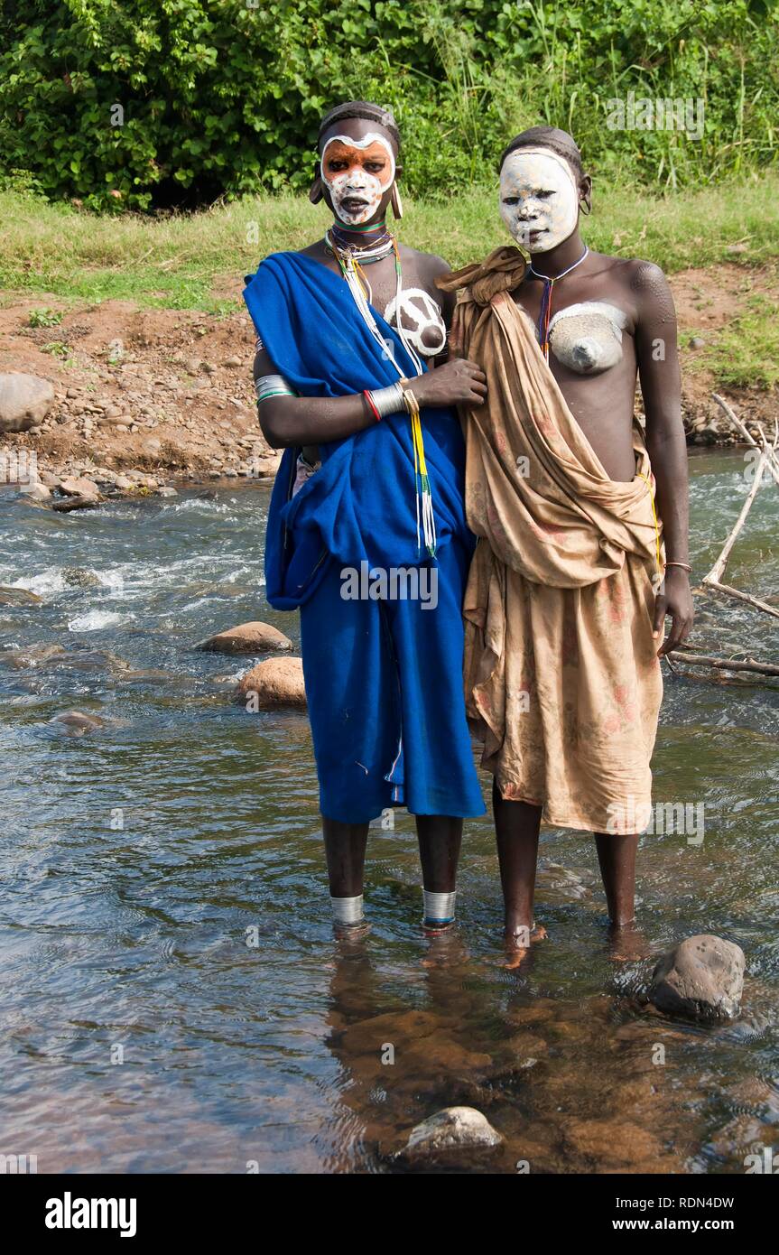 Due giovani donne Surma con trattamenti per il viso e per il corpo dipinto dal fiume Kibish, Omo River Valley, Etiopia, Africa Foto Stock