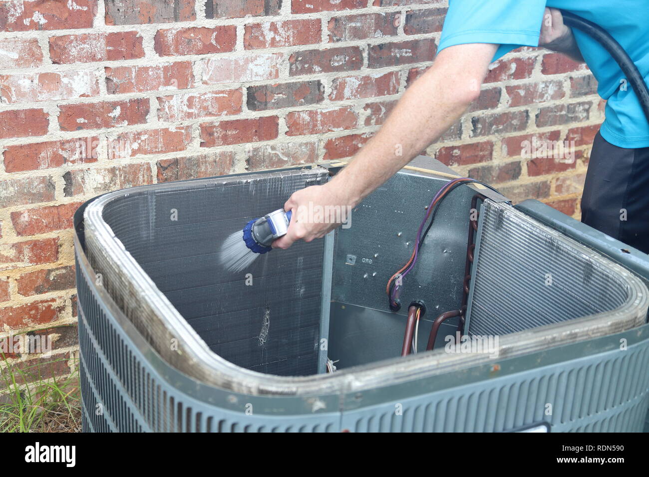 La pulizia il condensatore del condizionatore aria bobina con acqua per  rimuovere la sporcizia e i detriti Foto stock - Alamy