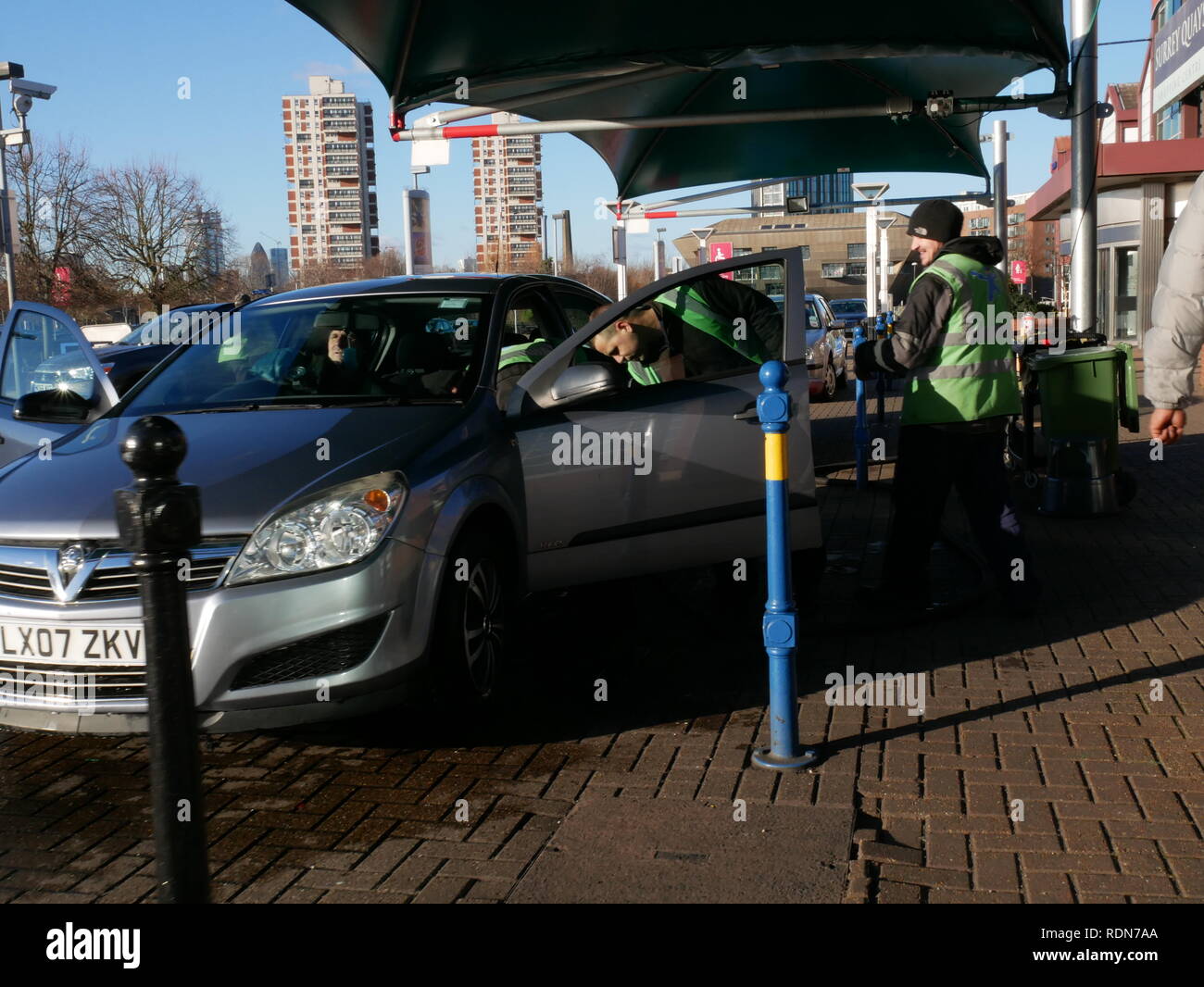 Gli uomini Servizio di presa e consegna auto accanto a Surrey Quays Shopping Centre, Canada Water, Londra. Foto Stock