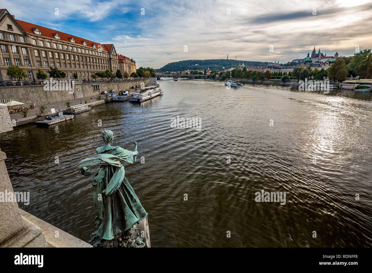 Praga, Repubblica Ceca - 27 agosto 2015: Tour barche a vela e passare dalla torcia di bronzo del cuscinetto figura femminile statua con patina, Cech Bridge, il fiume Moldava Foto Stock