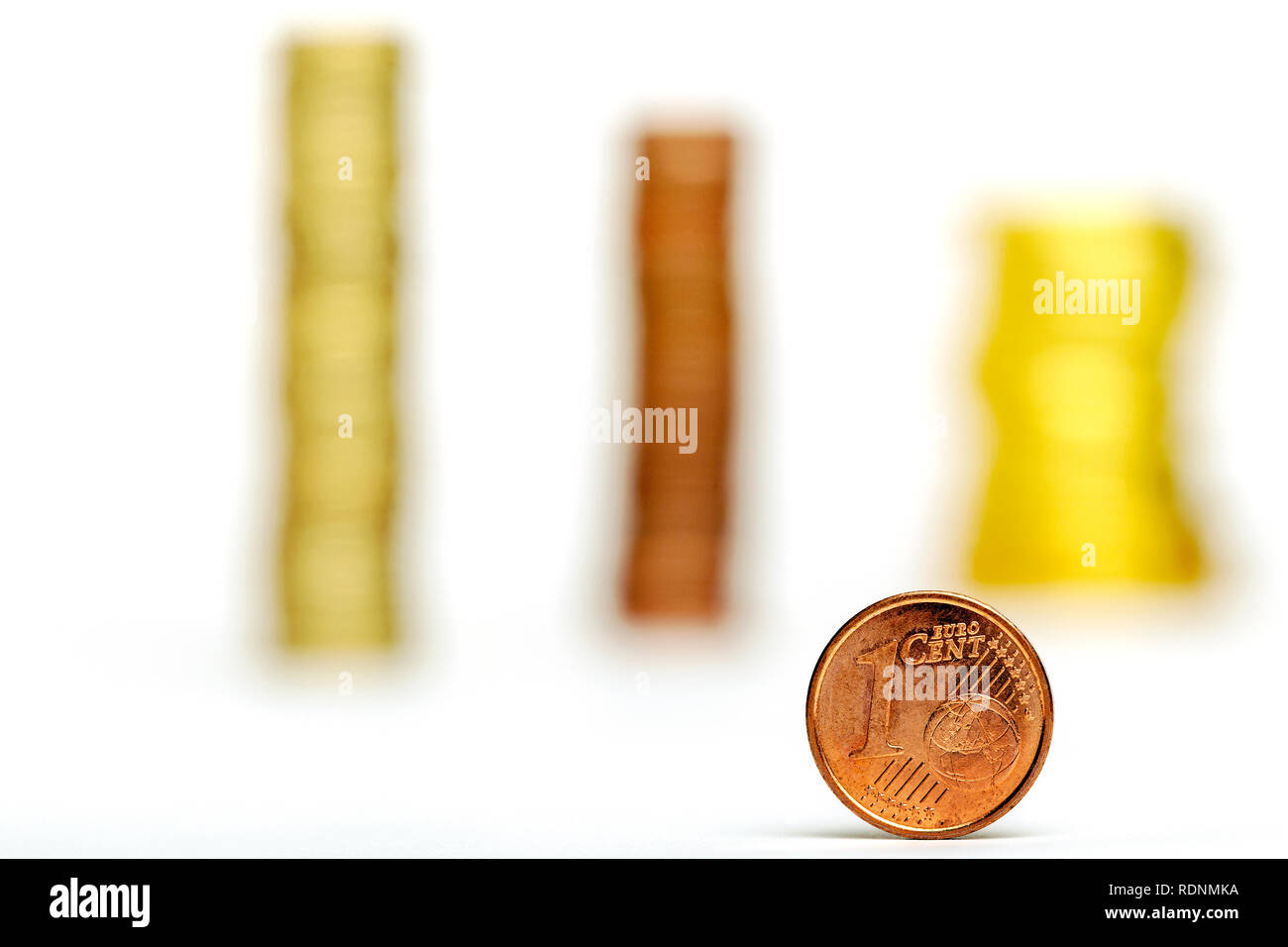Close up di un centesimo di Euro e pile di monete su sfondo bianco Foto Stock