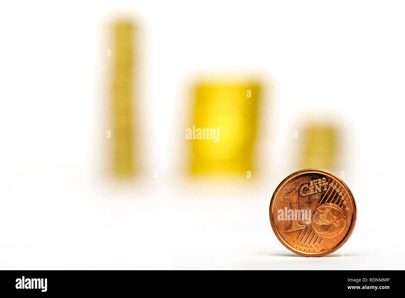 Close up di un centesimo di Euro e pile di monete su sfondo bianco Foto Stock