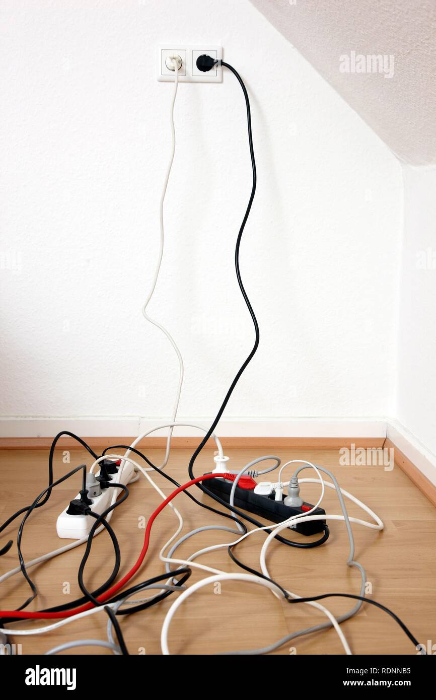 Più ciabatte per la connessione di dispositivi elettrici multipli, il groviglio di cavi, connettori e unità di alimentazione Foto Stock