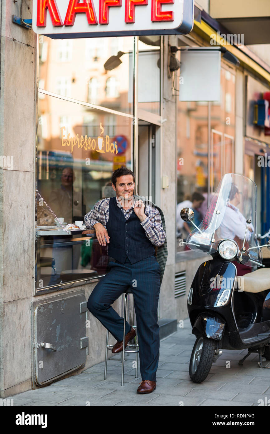 Metà uomo adulto seduto al cafè sul marciapiede Foto Stock