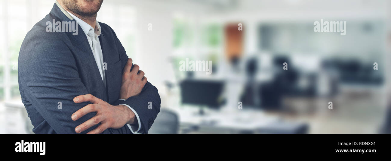 Imprenditore in piedi su sfondo di office con le braccia incrociate di spazio di copia Foto Stock