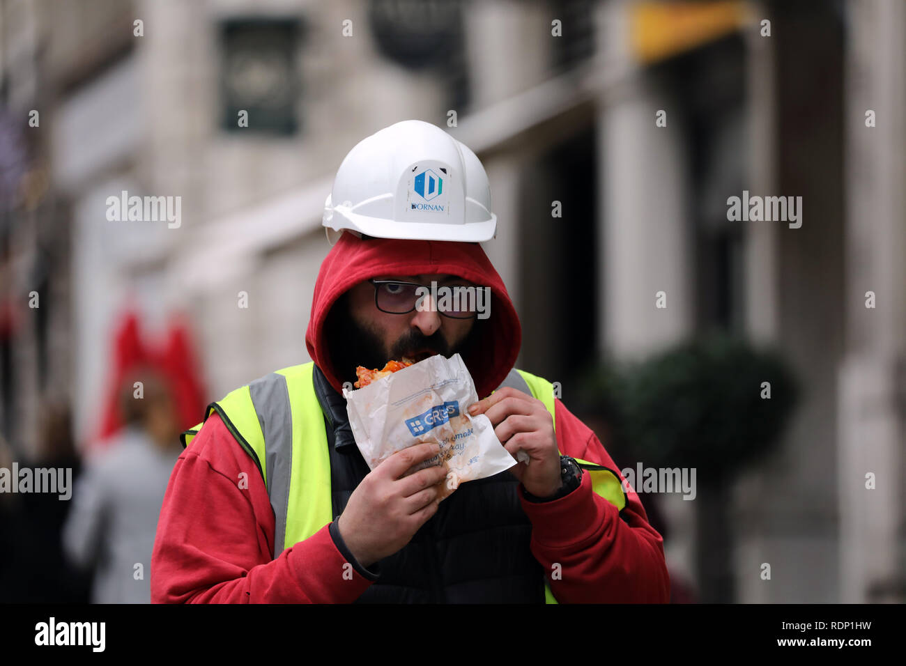 Costruttori di mangiare cibo Greggs camminando lungo Foto Stock