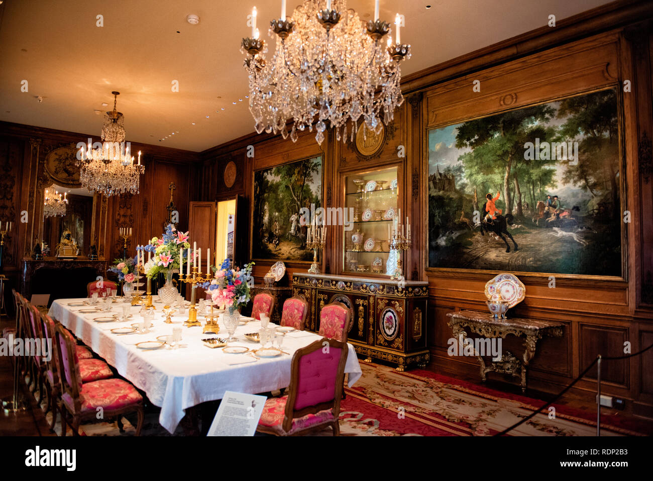 Sala da pranzo principale di Hillwood Estate Washington DC | WASHINGTON DC — La sala da pranzo principale di Hillwood Estate, Museo e Giardini, le sue pareti rivestite di pannellatura di quercia recuperata da una casa parigina dei primi anni 1700. L'architetto Alexander McIlvaine ricostruì gli interni della magione neogeorgiana tra il 1955 e il 1957 per la collezionista Marjorie Merriweather Post, attingendo a stili rococò e neoclassici francesi del XVIII secolo e incorporando elementi architettonici francesi d'epoca autentici. Post utilizzava la stanza per intrattenere l'élite sociale e politica di Washington, e faceva apparecchiare la tavola con pezzi Foto Stock