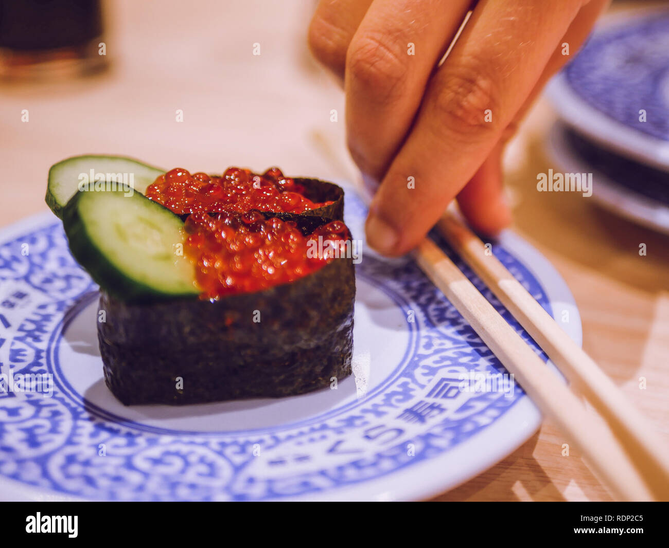 Sushi a fuoco con più piastre in background Foto Stock