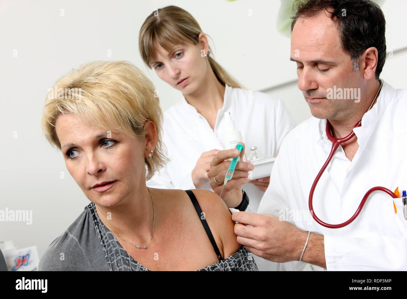 Ambulatorio medico e paziente avente un'iniezione con una siringa monouso, immunizzazione Foto Stock