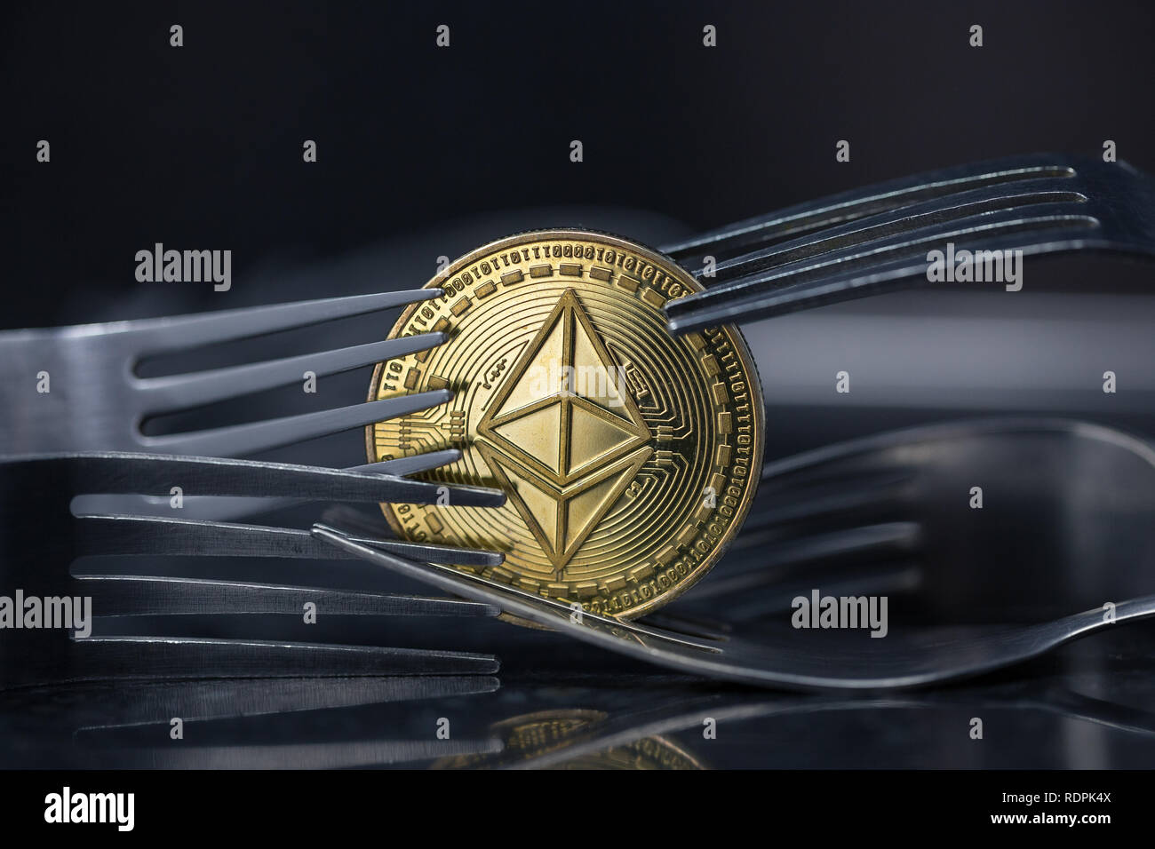 Ethereum Classic cryptocurrency moneta fisica collocato tra le forcelle in metallo Foto Stock