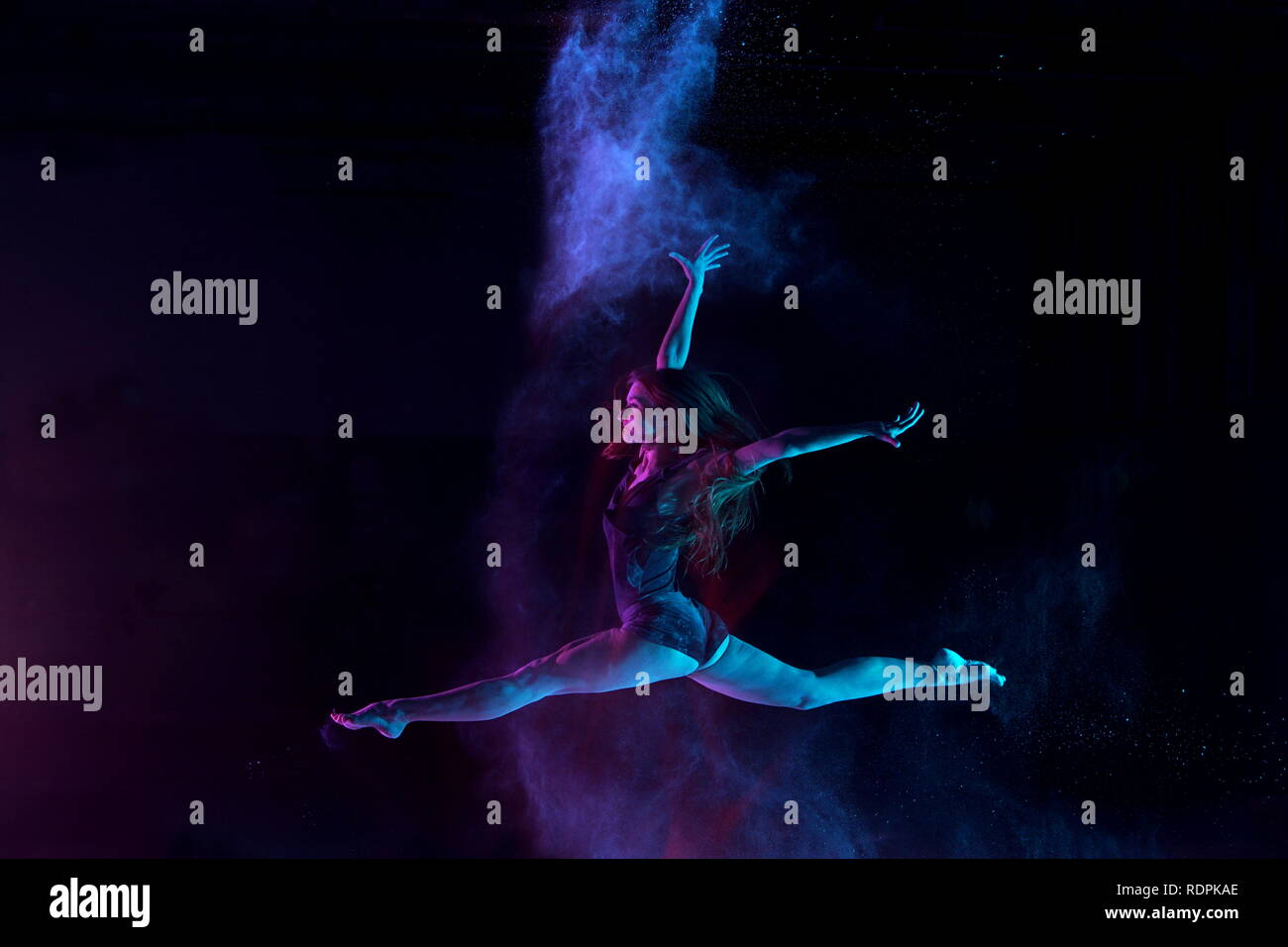 Capelli lunghi ballerina Sforbiciata con salto con polvere Foto Stock