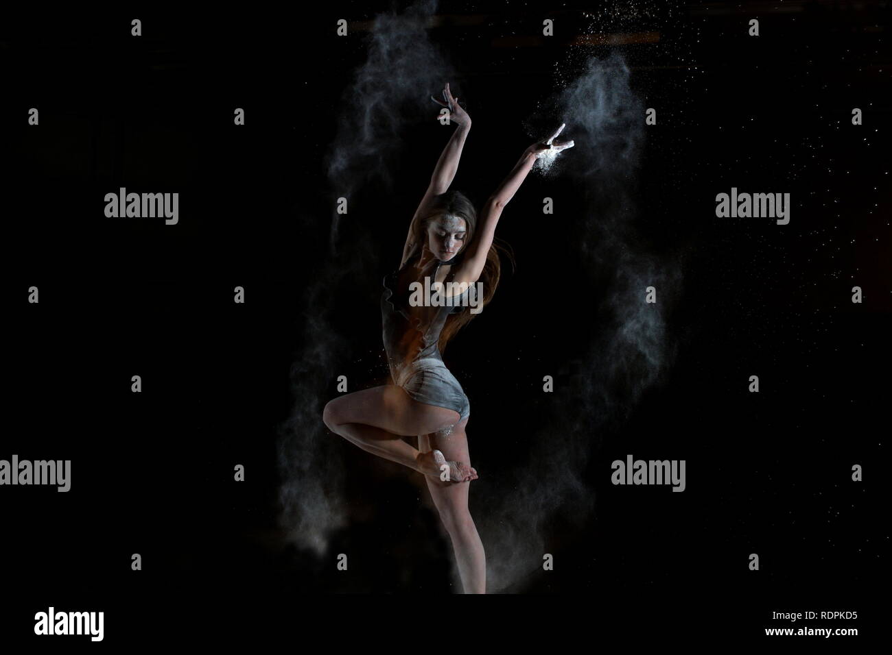 La ballerina il salto con la polvere sul palco Foto Stock
