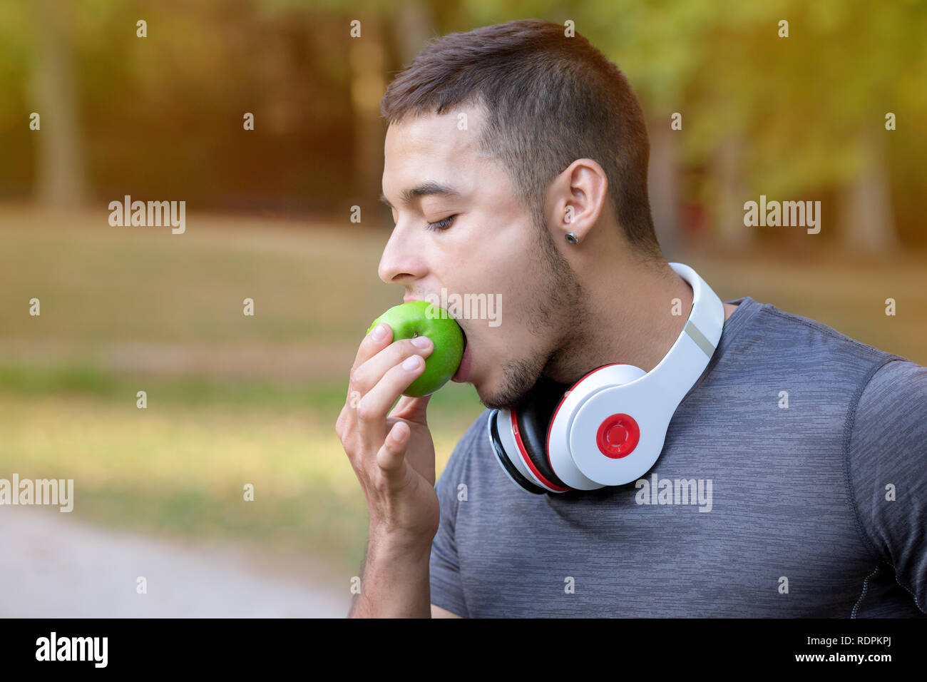 Runner uomo latino mangiare Apple esegue il jogging sport fitness training copyspace copia spazio all'aperto Foto Stock