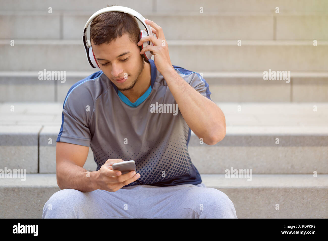 Ascolto di musica latina giovane uomo ascoltare le cuffie copyspace copia spazio all'aperto Foto Stock