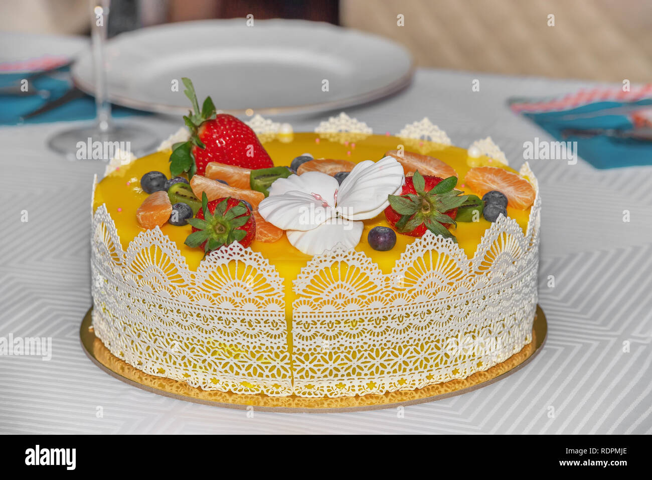 Bella la deliziosa torta di giallo con frutta e caramello decorazioni con una gelatina di liscia superficie. Foto Stock