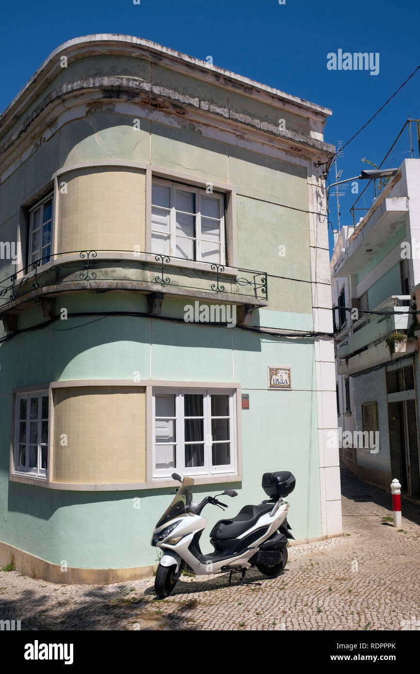 Uno scooter parcheggiava fuori da un edificio verde pallido, Vila Real de Santo António, Portogallo, Europa Foto Stock