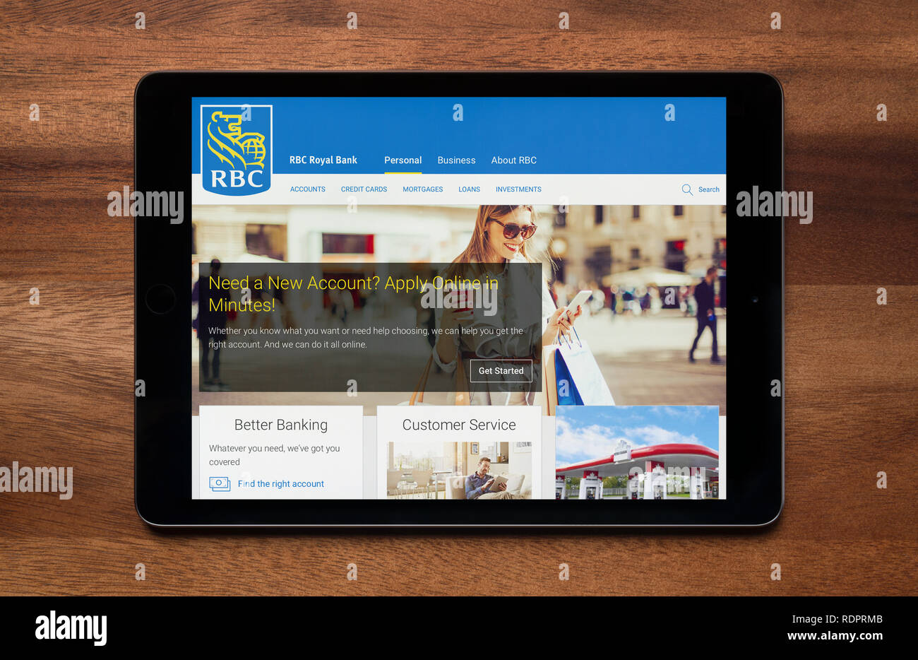 Il sito Web di RBS (Royal Bank of Canada) è visto su un tablet iPad, il quale è appoggiato su un tavolo di legno (solo uso editoriale). Foto Stock