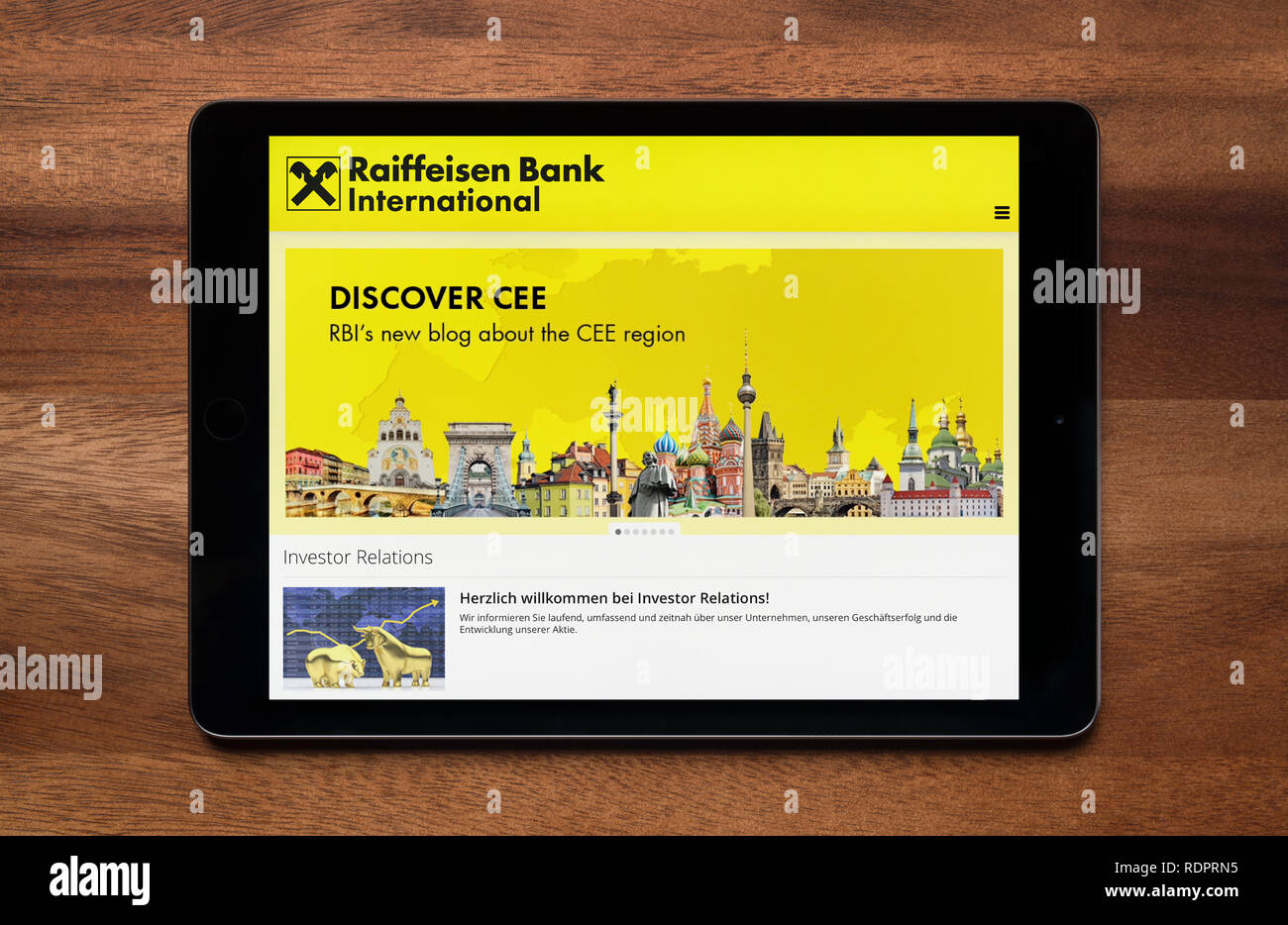 Il sito web della Banca Raiffeisen International è visto su un tablet iPad, il quale è appoggiato su un tavolo di legno (solo uso editoriale). Foto Stock