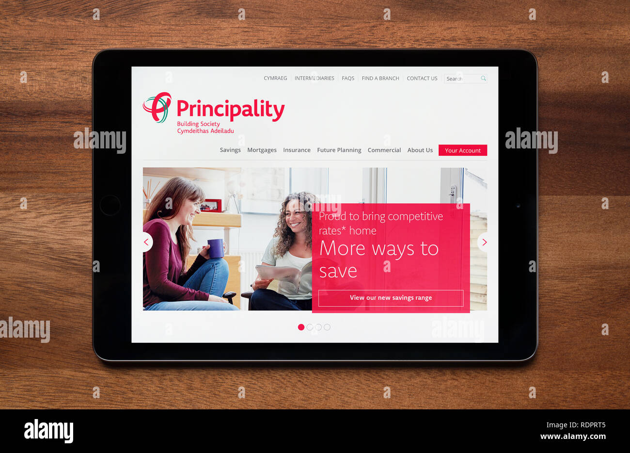 Il sito web del Principato la costruzione della società è visto su un tablet iPad, il quale è appoggiato su un tavolo di legno (solo uso editoriale). Foto Stock