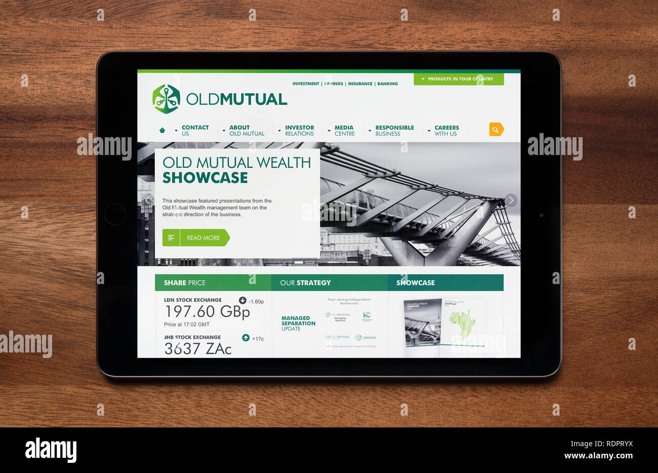 Il sito web di Old Mutual è visto su un tablet iPad, il quale è appoggiato su un tavolo di legno (solo uso editoriale). Foto Stock