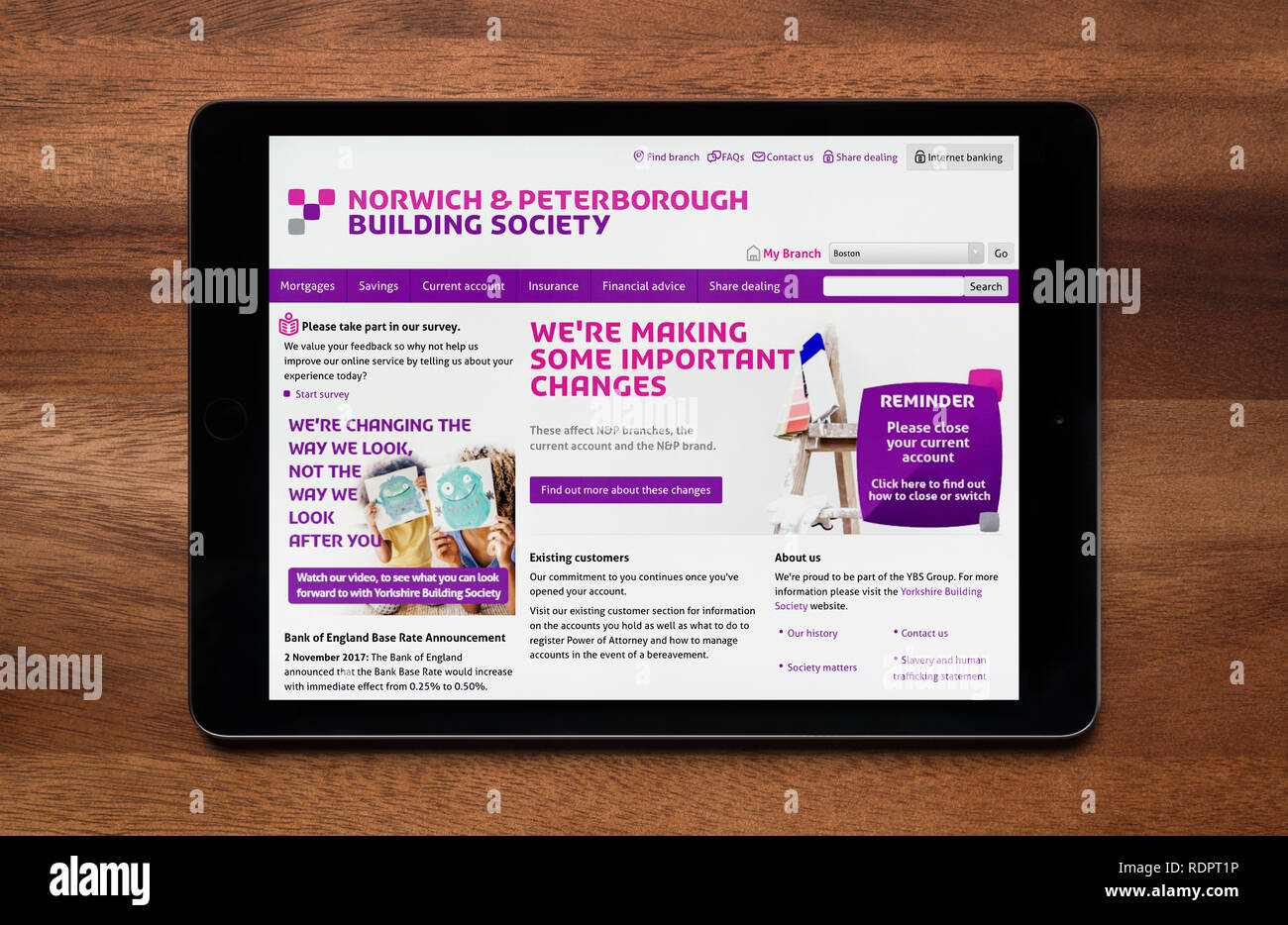 Il sito web di Norwich e Peterborough Building Society è visto su un tablet iPad, il quale è appoggiato su un tavolo di legno (solo uso editoriale). Foto Stock