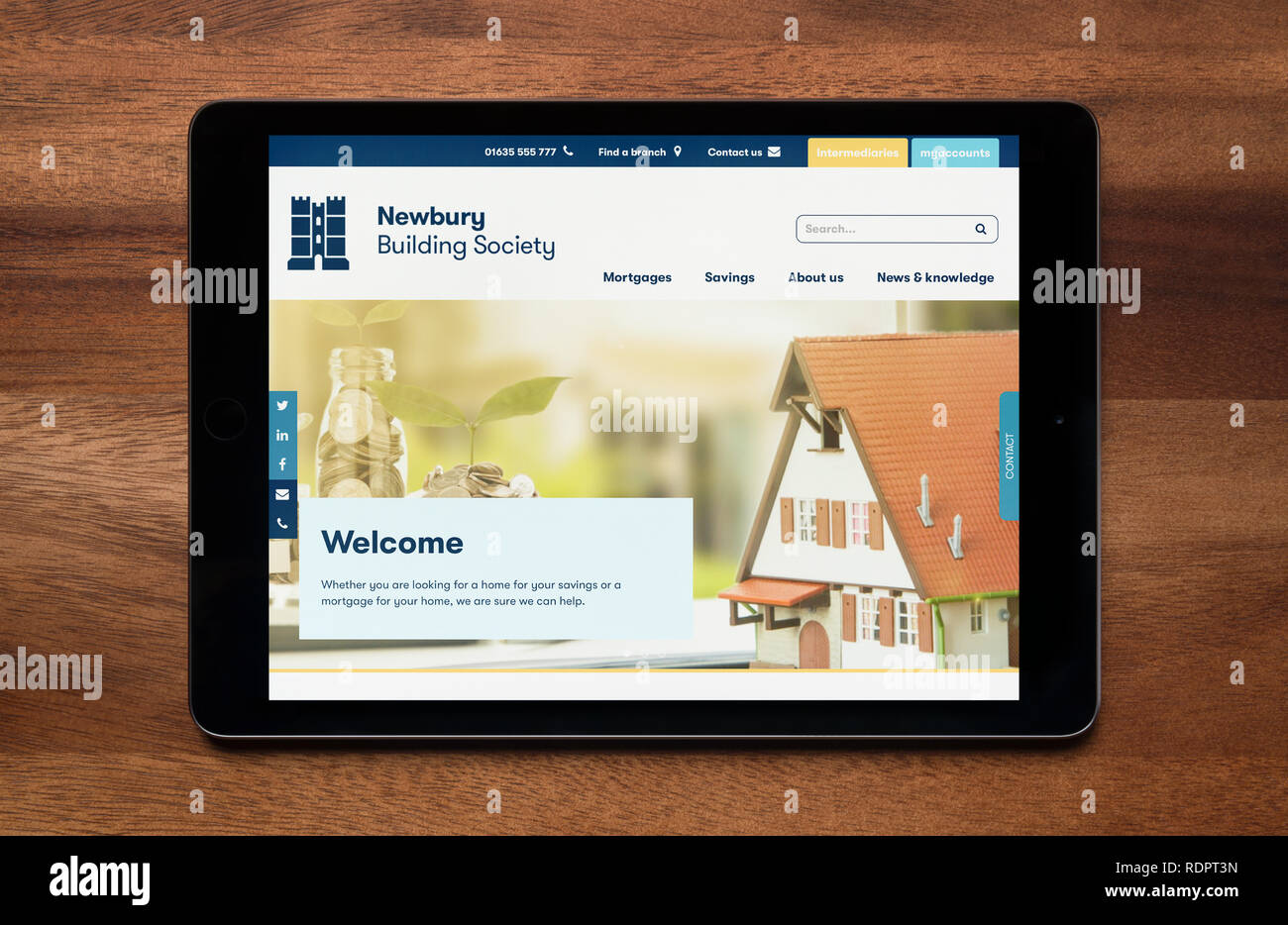 Il sito web di Newbury Building Society è visto su un tablet iPad, il quale è appoggiato su un tavolo di legno (solo uso editoriale). Foto Stock