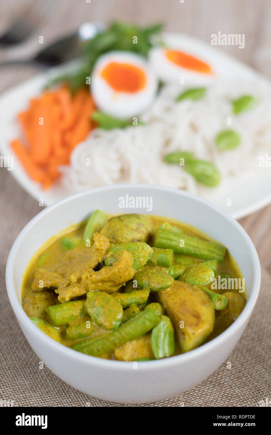 Il cibo thai piccante di carne di maiale e di Parkia vegetale speciosa curry in latte di cocco tailandese e farina di riso tagliatelle Foto Stock