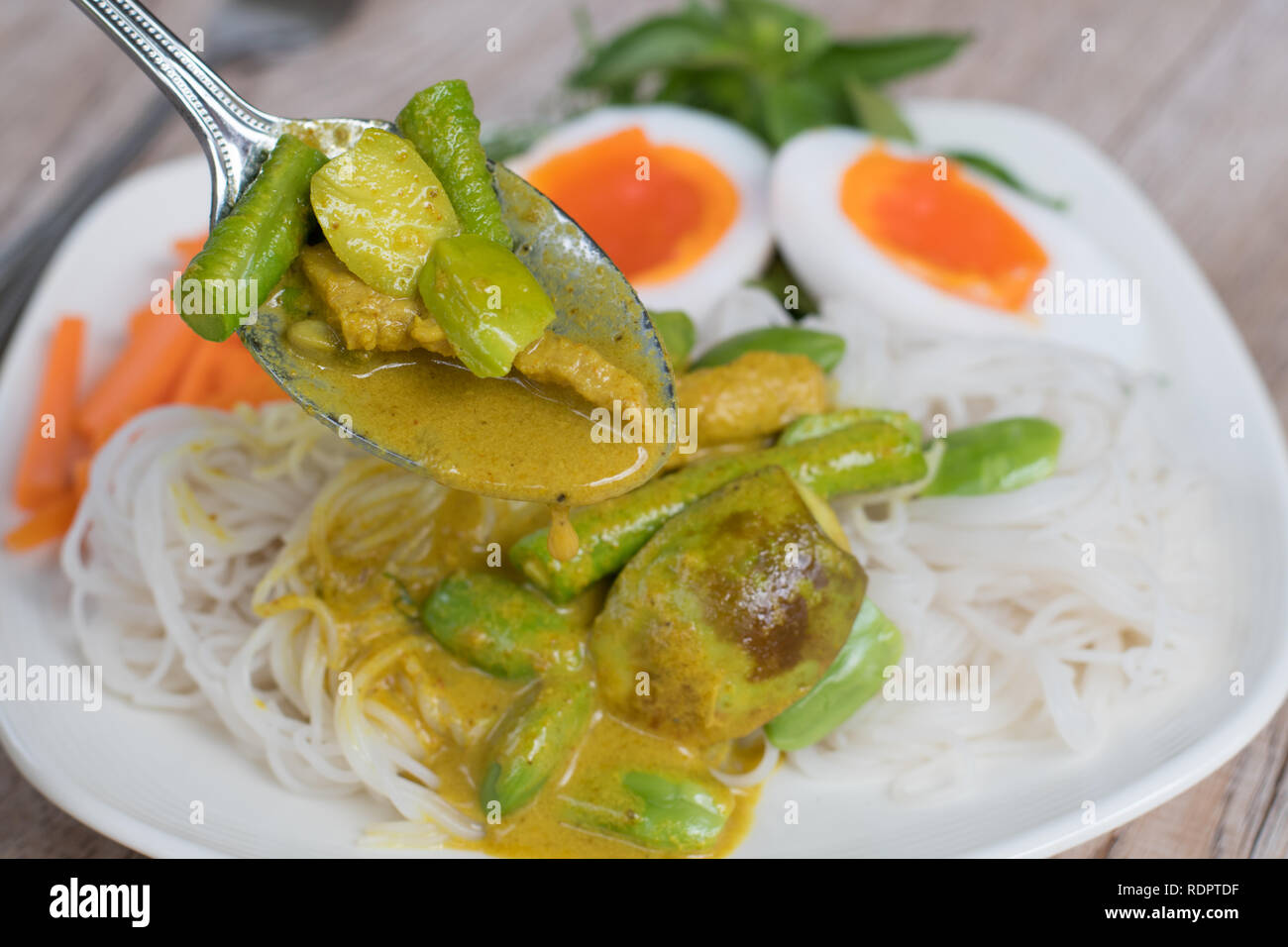 Il cibo thai piccante di carne di maiale e di Parkia vegetale speciosa curry in latte di cocco tailandese e farina di riso tagliatelle Foto Stock