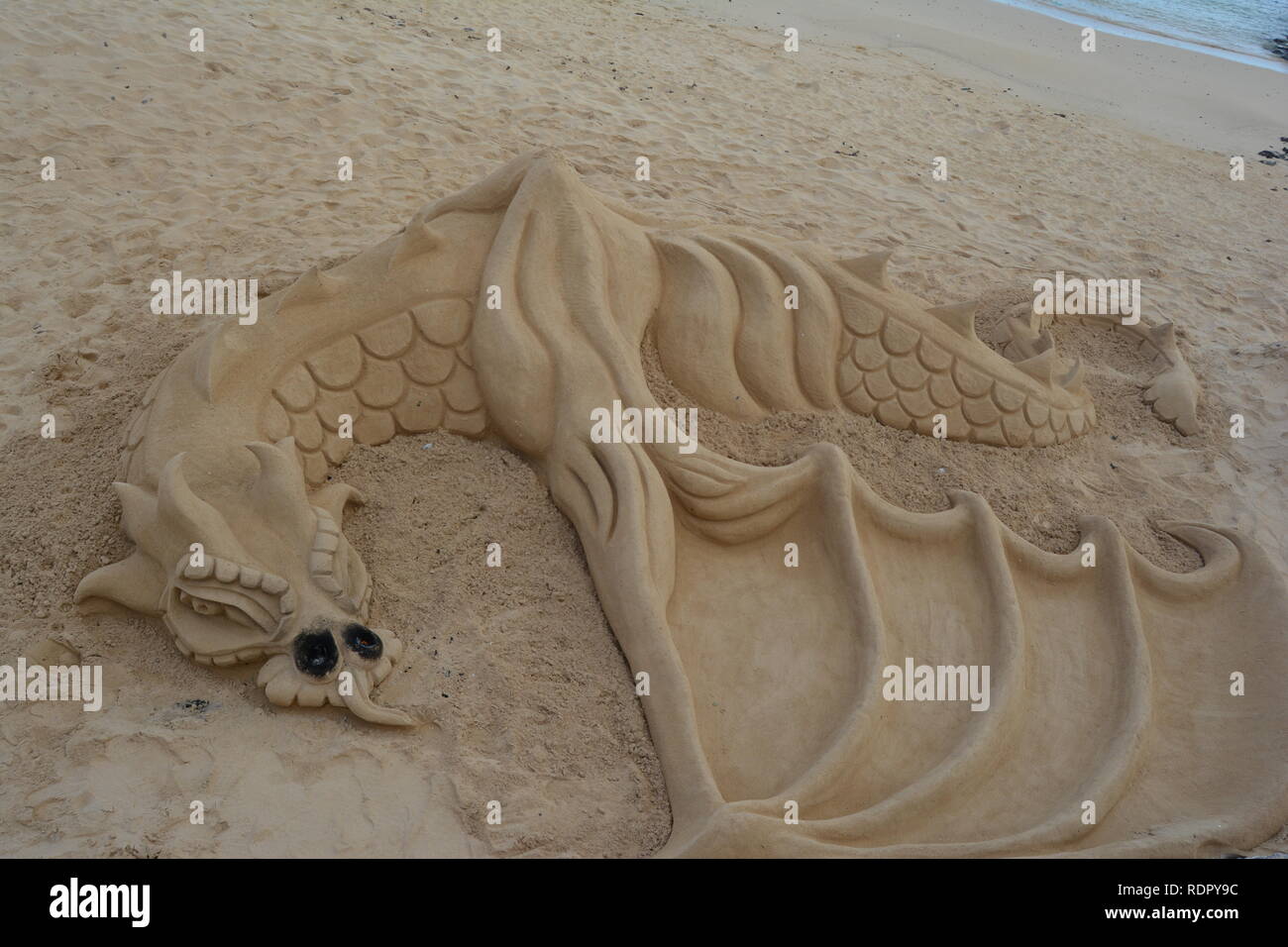 Arte di strada. Drago di sabbia sulla spiaggia Corralejo. Foto Stock