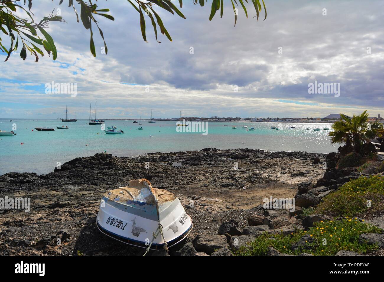Vecchia barca abbandonata sulla costa rocciosa di Corralejo. Oceano turchese e scenic sky in background. Fuerteventura, Spagna. Foto Stock
