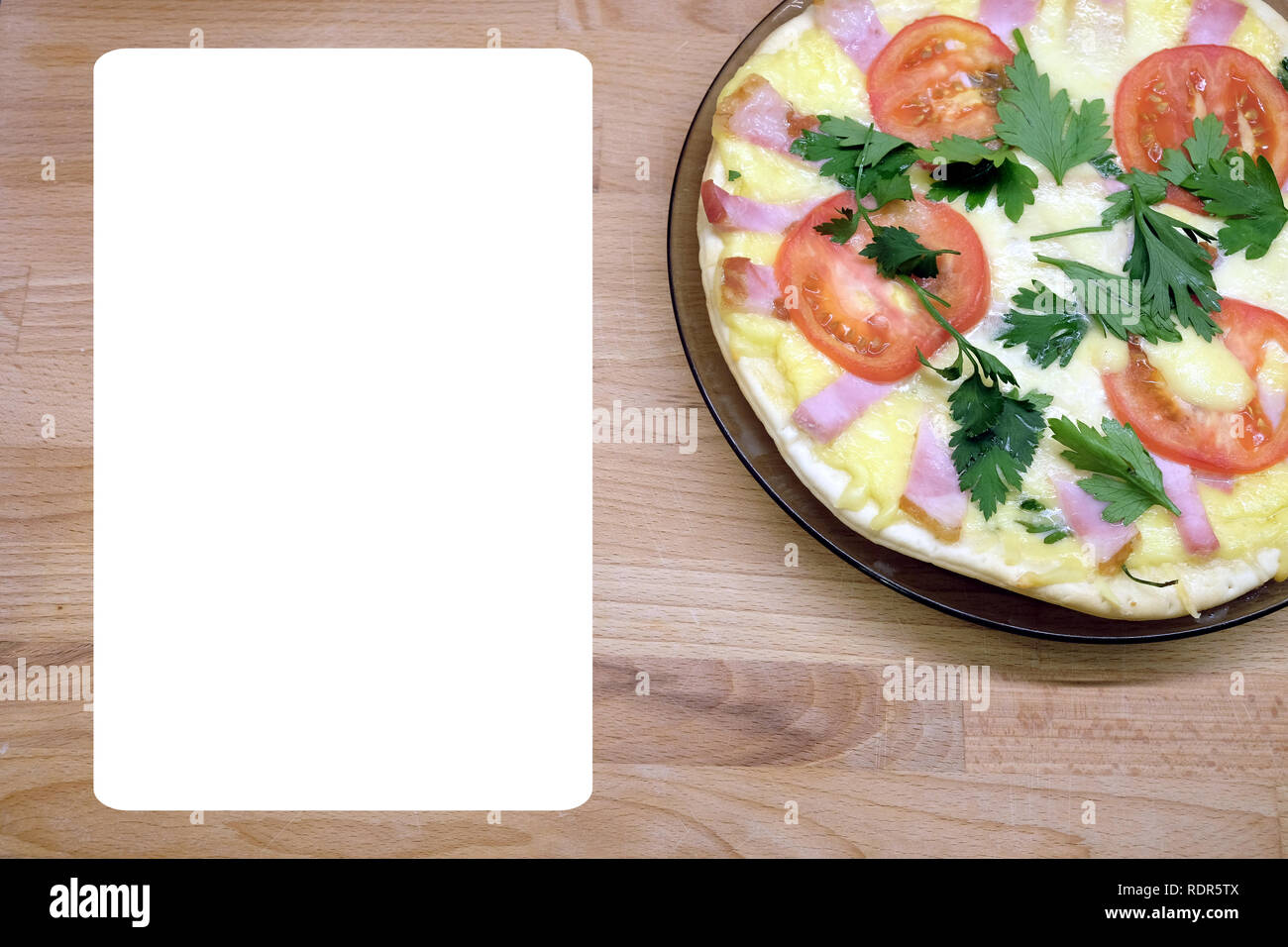 Frammento della piastra preparata con gustosa pizza con pomodori, pancetta e formaggio con vuoto foglio bianco per il testo del menu su sfondo di legno vista superiore Foto Stock