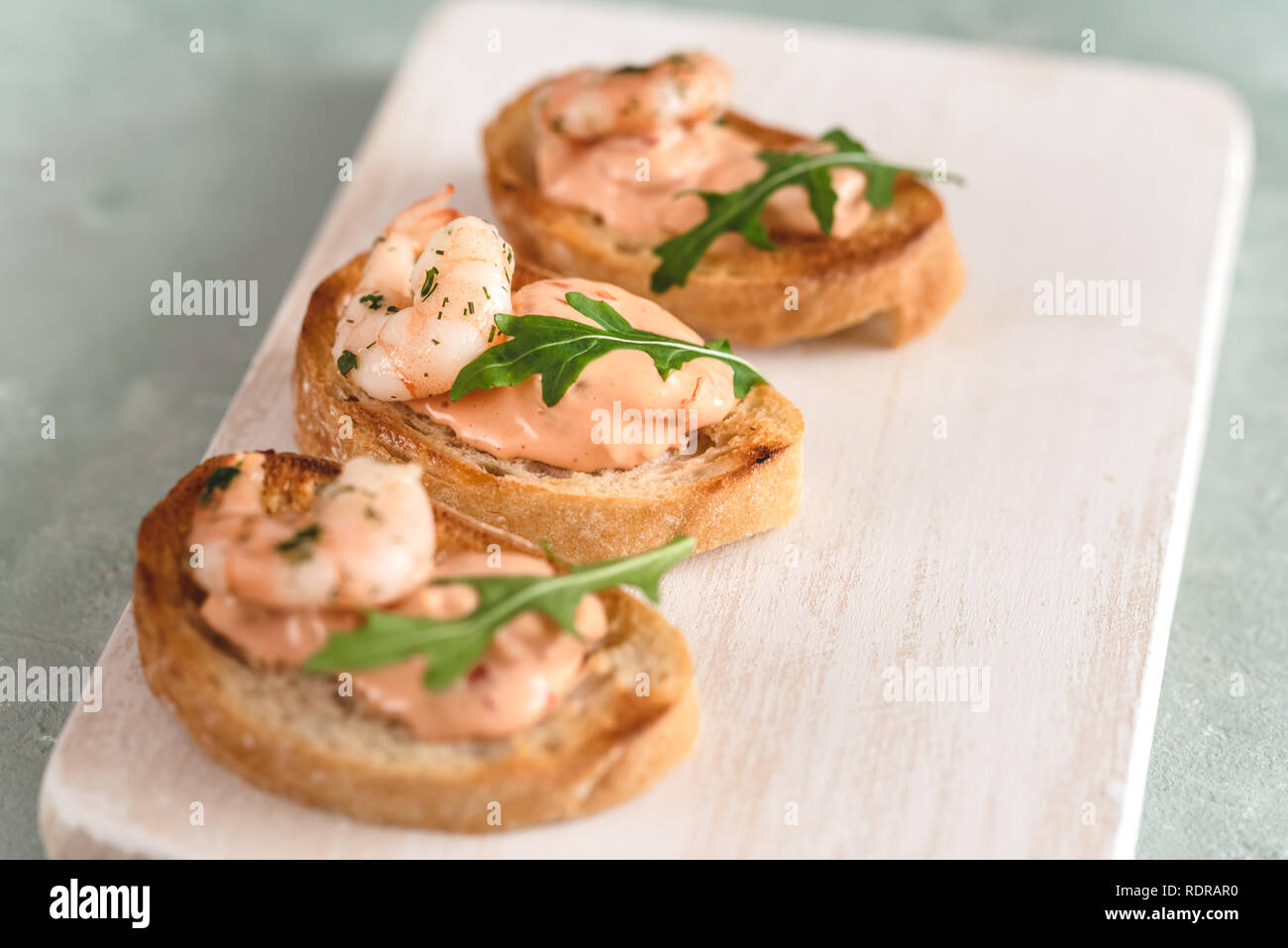 La bruschetta panini con gamberetti, cremosa salsa di pomodoro e rucola. Foto Stock