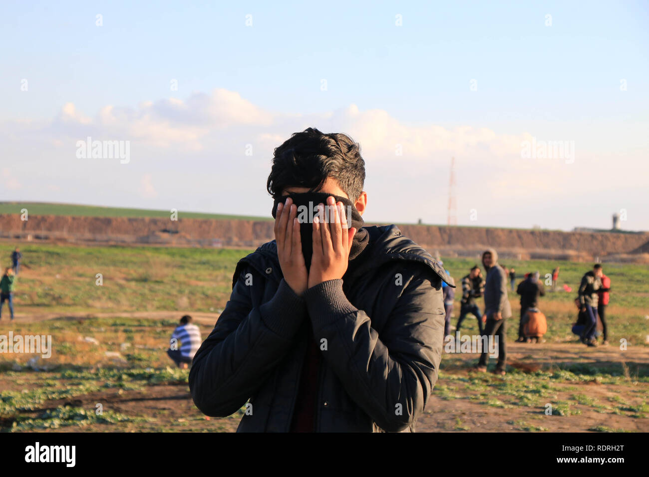Una gioventù palestinese visto soffocante con gas lacrimogeni durante le dimostrazioni di tra i cittadini palestinesi e forze di occupazione israeliane in segno di protesta contro il riconoscimento del Presidente americano Trump Gerusalemme come capitale di Israele ad est della città di Gaza. Foto Stock