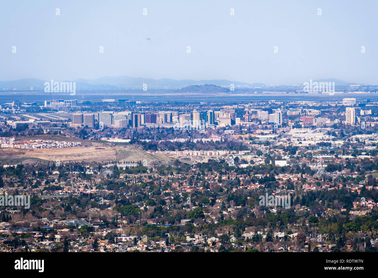 Vista aerea del centro cittadino di San Jose in un giorno chiaro; quartieri residenziali in primo piano; Santa Clara e la baia di San Francisco in background; Sil Foto Stock