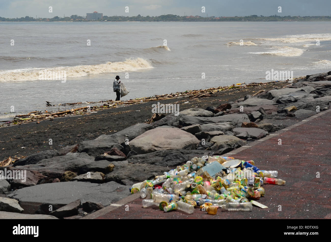 La gente raccoglie le bottiglie di plastica sulla costa inquinata Foto Stock
