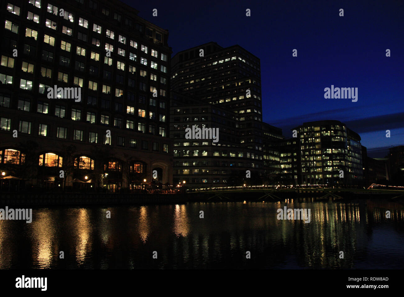 Vista notturna di torri di uffici che riflette nell'acqua del fiume Tamigi a Canary Wharf, London, Regno Unito Foto Stock