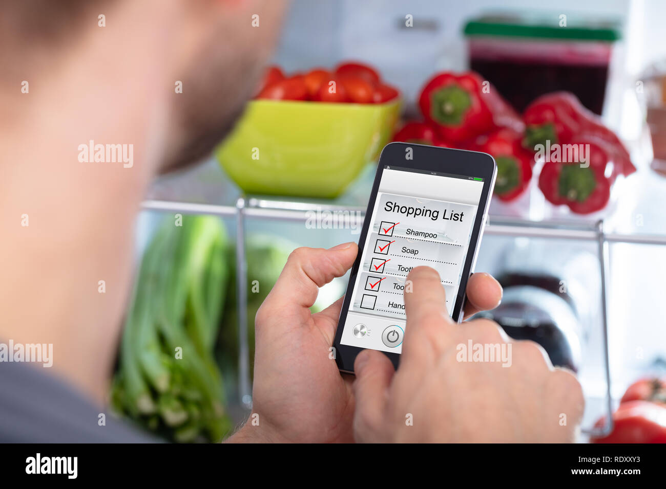 Close-up di un uomo marcatura Shopping List sul telefono cellulare Foto Stock