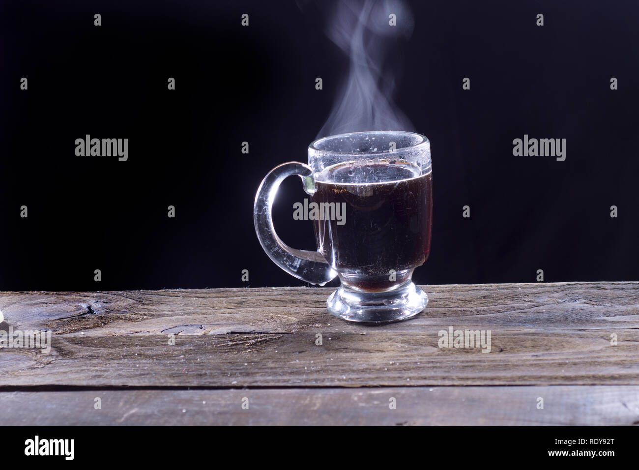 Fumante tazza di caffè nero su un tavolo in legno Foto Stock