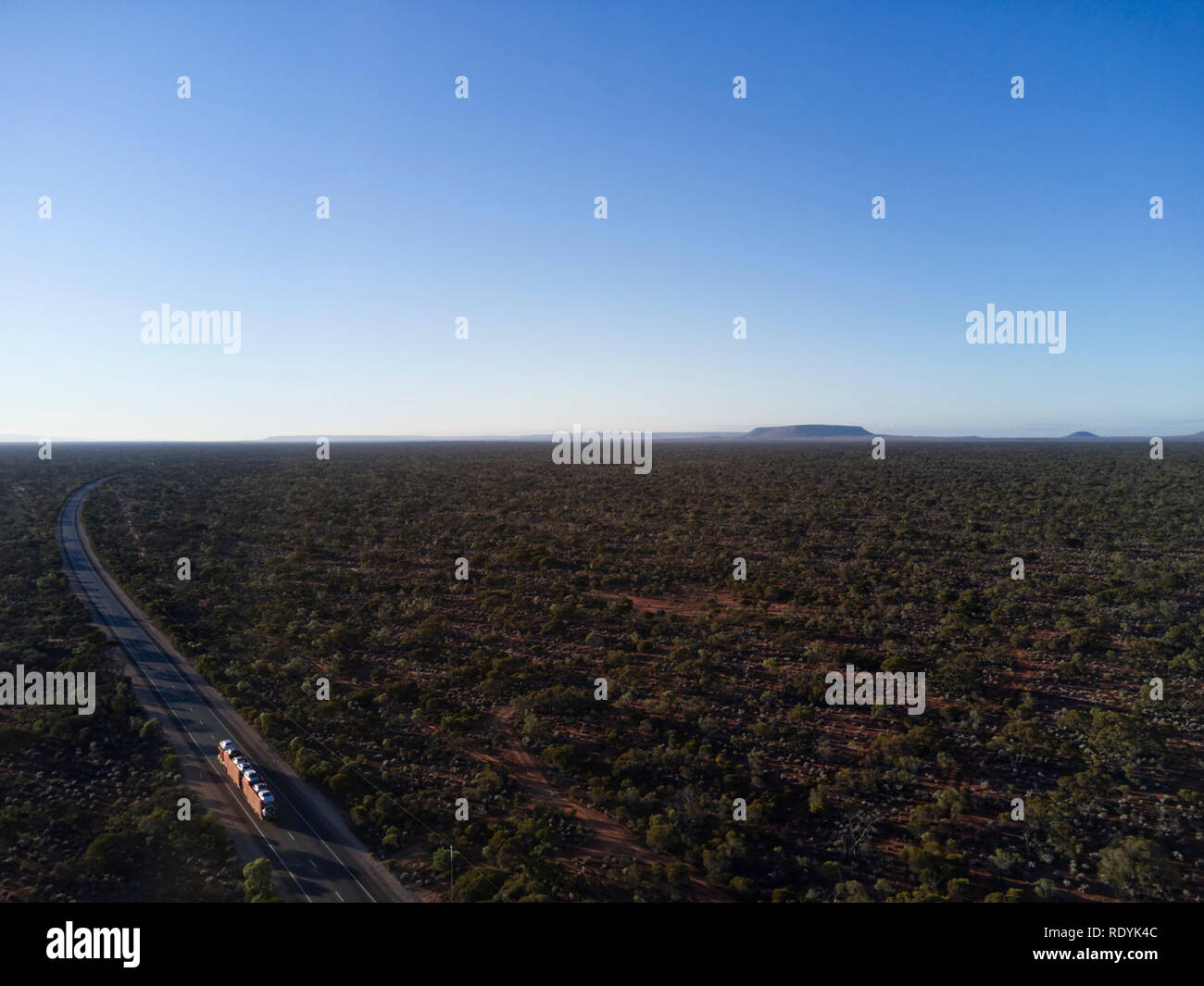 Antenna treno su strada sulla Stuart Highway che mostra il vasto orizzonte piana del bush australiano appena al di fuori del Porto Augusta Sud Australia Foto Stock