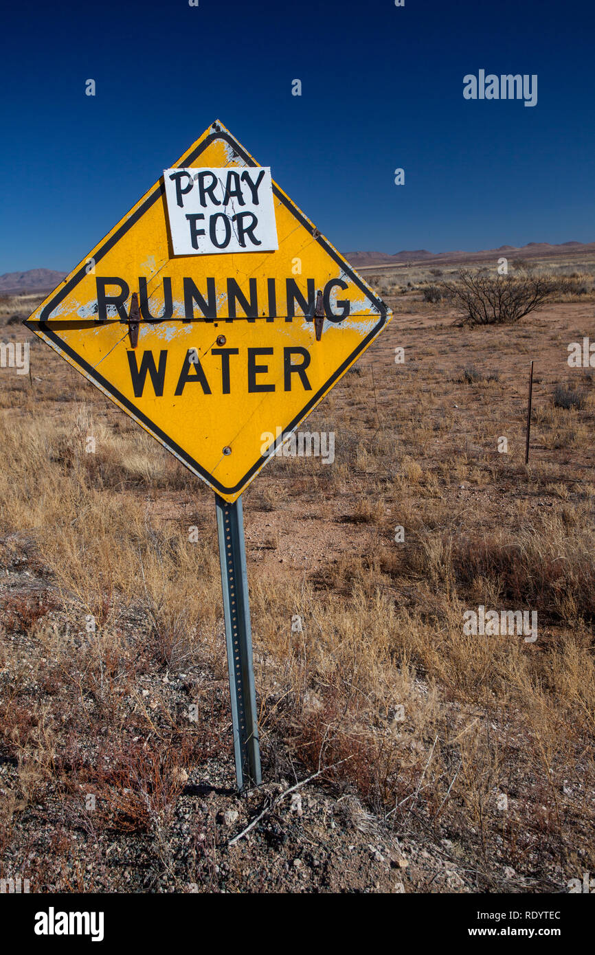 Pregare per l'esecuzione di acqua un segno umoristico puntando alla siccità nel sud-ovest del Nuovo Messico in età di cambiamento climatico globale Foto Stock