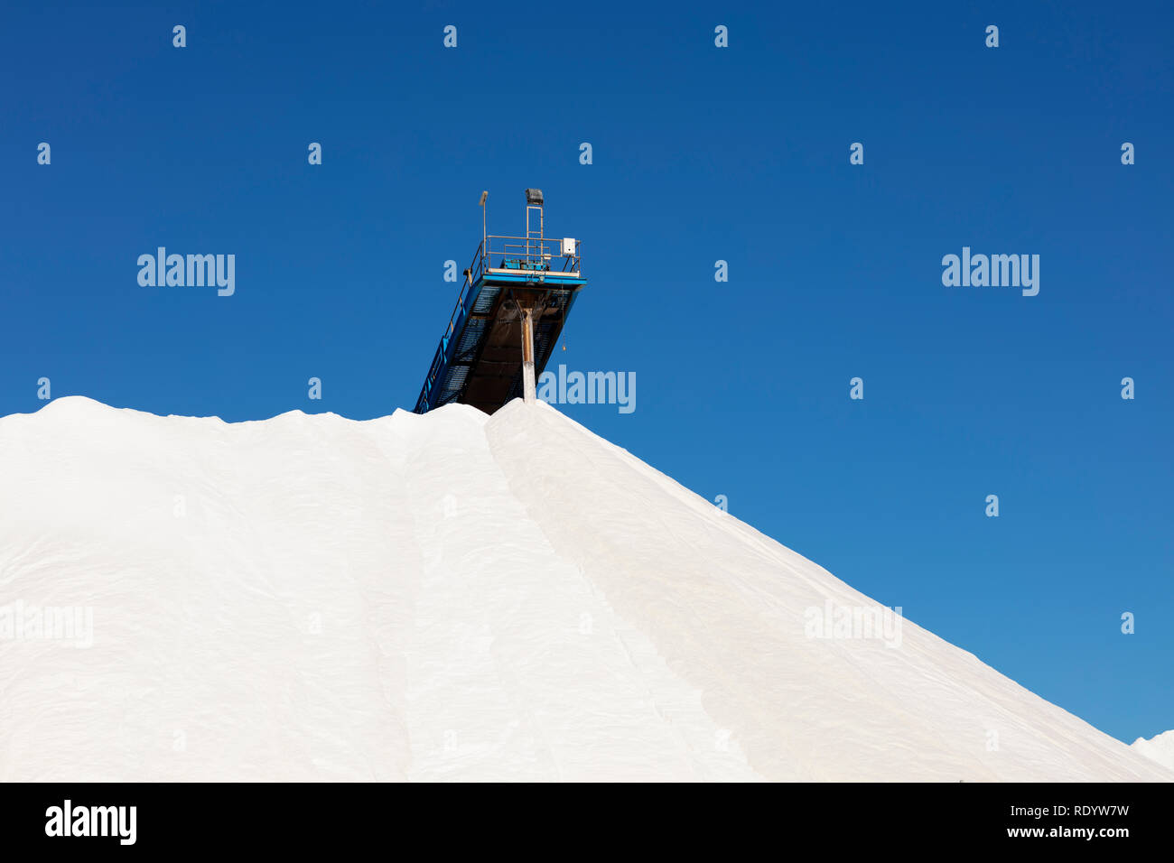 Montagna di sale bianco sul cielo blu, sale procedimento di estrazione e impilati Foto Stock