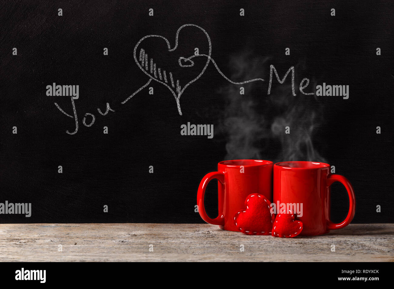 Il giorno di San Valentino concetto con red tazze, chalk iscrizione e feltro rosso cuori Foto Stock