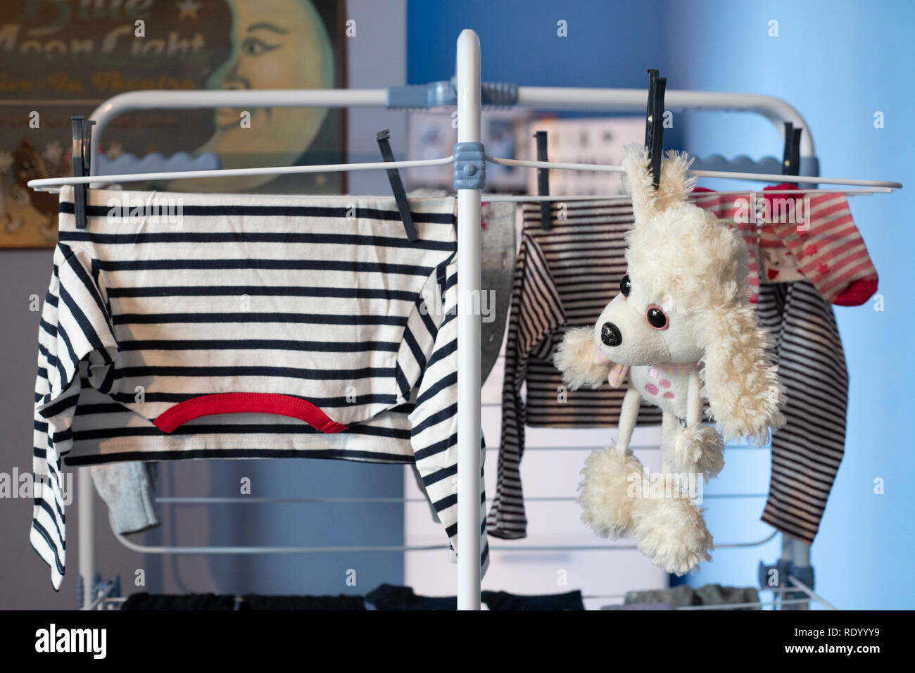 White cane giocattolo di peluche appesa a secco con servizio lavanderia indumenti dopo essere stato lavato. Vista frontale. Foto Stock