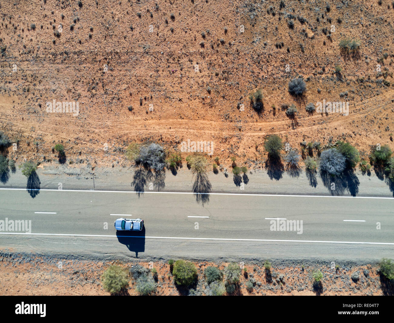 Nadir vista della strada sigillato in esecuzione attraverso il red colline di sabbia nel sud Outback australiano Foto Stock