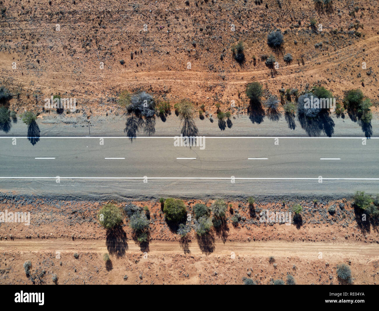 Nadir vista della strada sigillato in esecuzione attraverso il red colline di sabbia nel sud Outback australiano Foto Stock