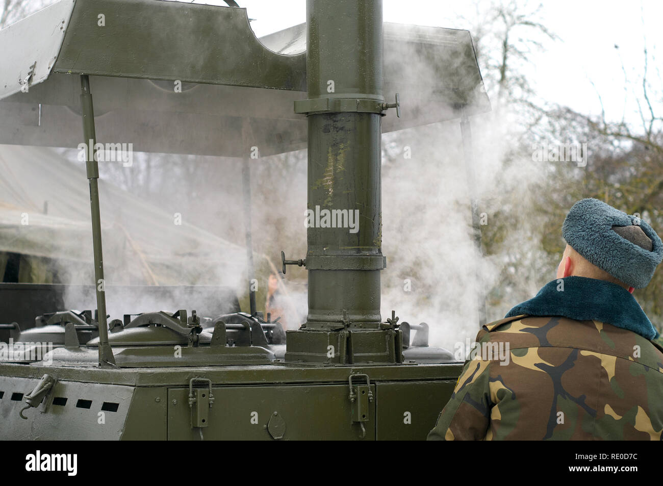 Un militare di cuoco prepara la cena per i soldati in inverno. Cucina e tenda. stile russo. Foto Stock