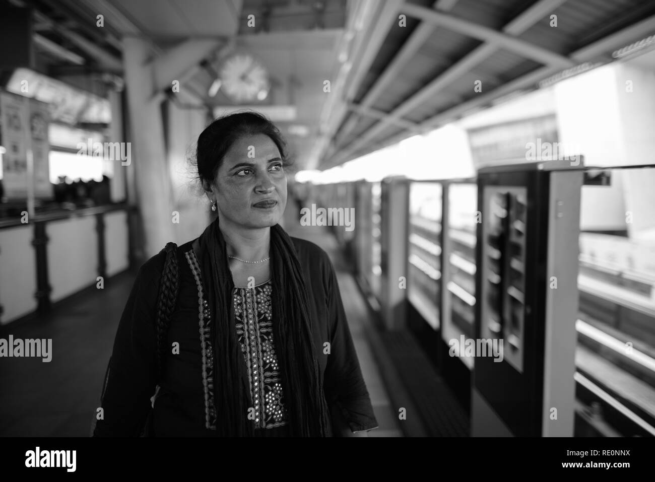 Donna indiana alla stazione ferroviaria di pensare in bianco e nero Foto Stock