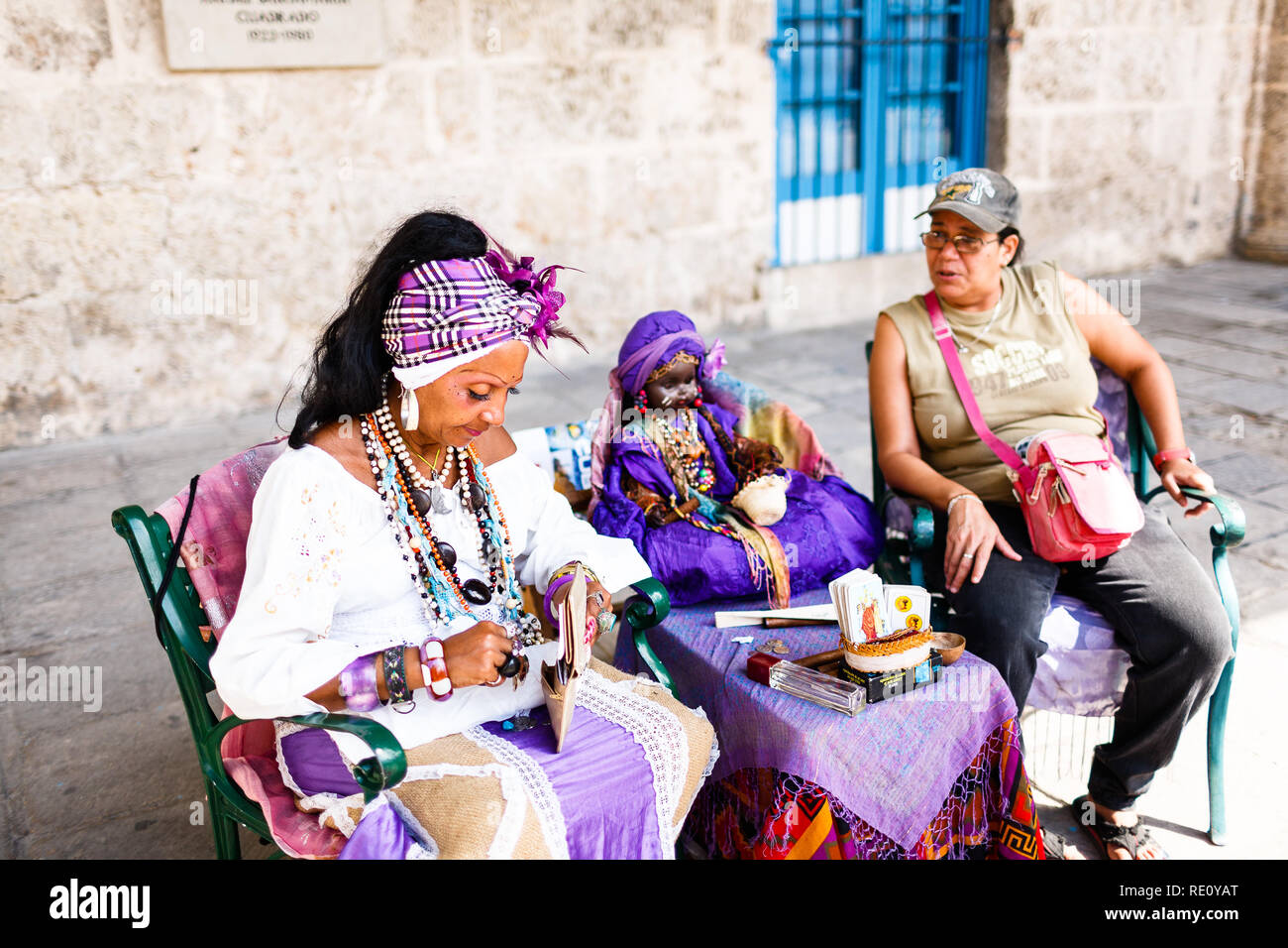 Di carnagione scura cubano bianco in costume racconta fortune a turisti in Havana strade Foto Stock